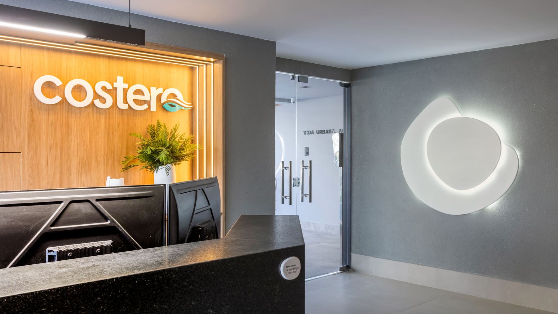 Recepção do Costero Residence com letreiro iluminado