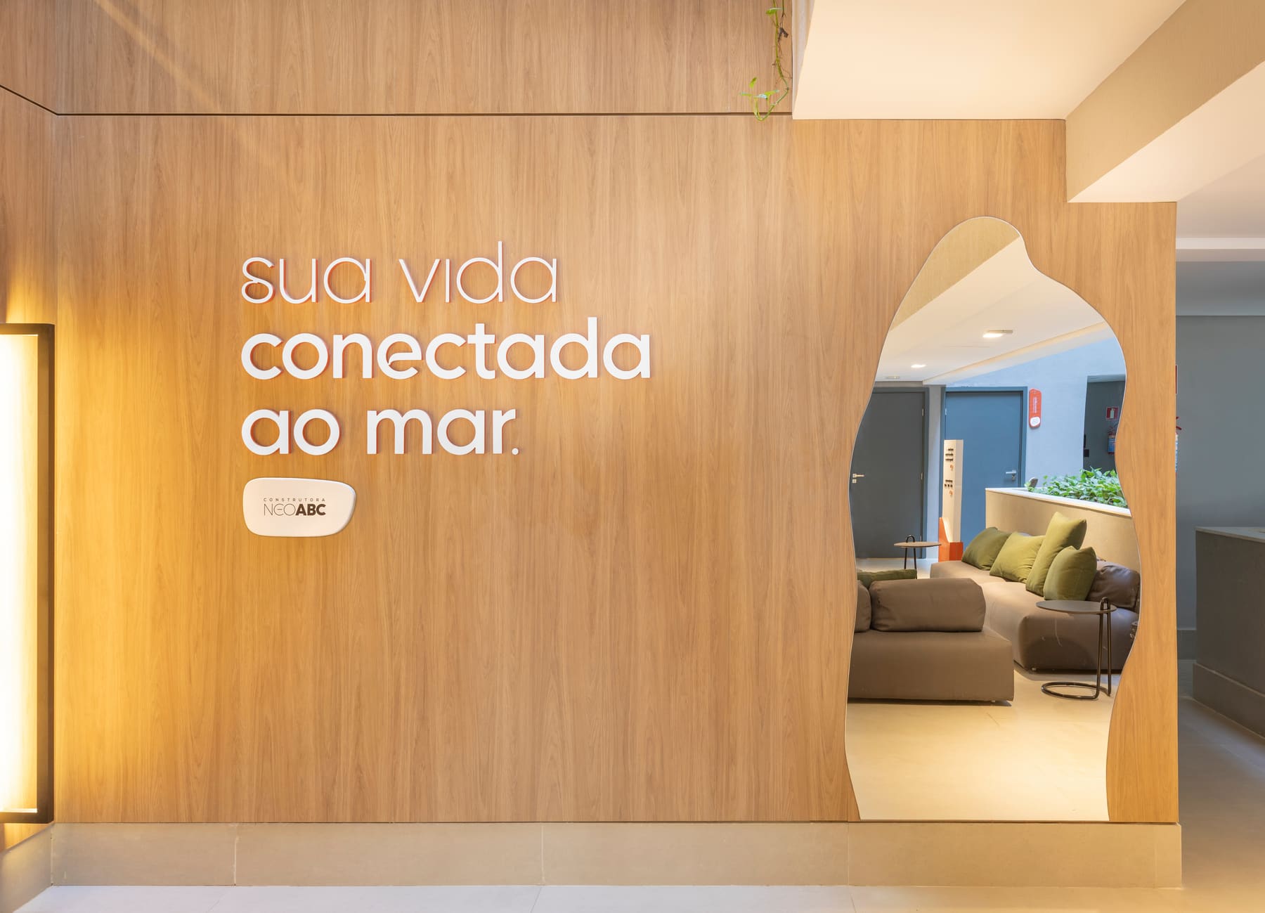 Parede com a frase 'Sua vida conectada ao mar' e recorte espelhado